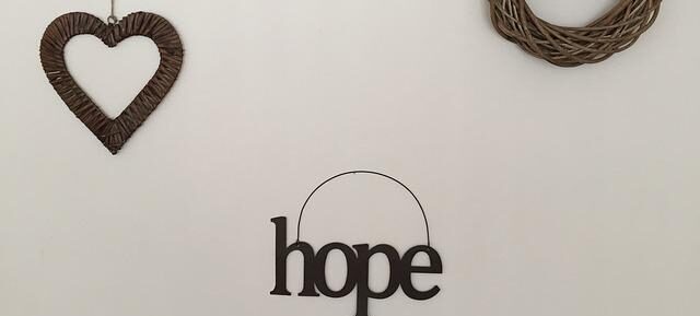 the word hope, a heart, and a wicker wreath on a wall